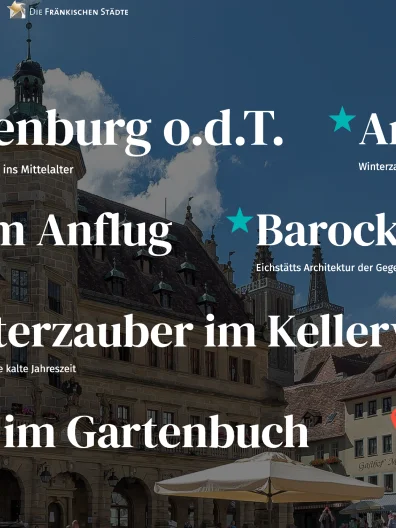 Historische Gebäude mit Fachwerk und Turm in einer Altstadt bei blauem Himmel und Wolken.