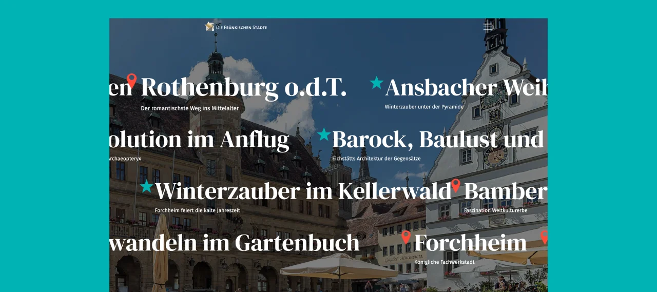 Historische Gebäude mit Fachwerk und Turm in einer Altstadt bei blauem Himmel und Wolken.